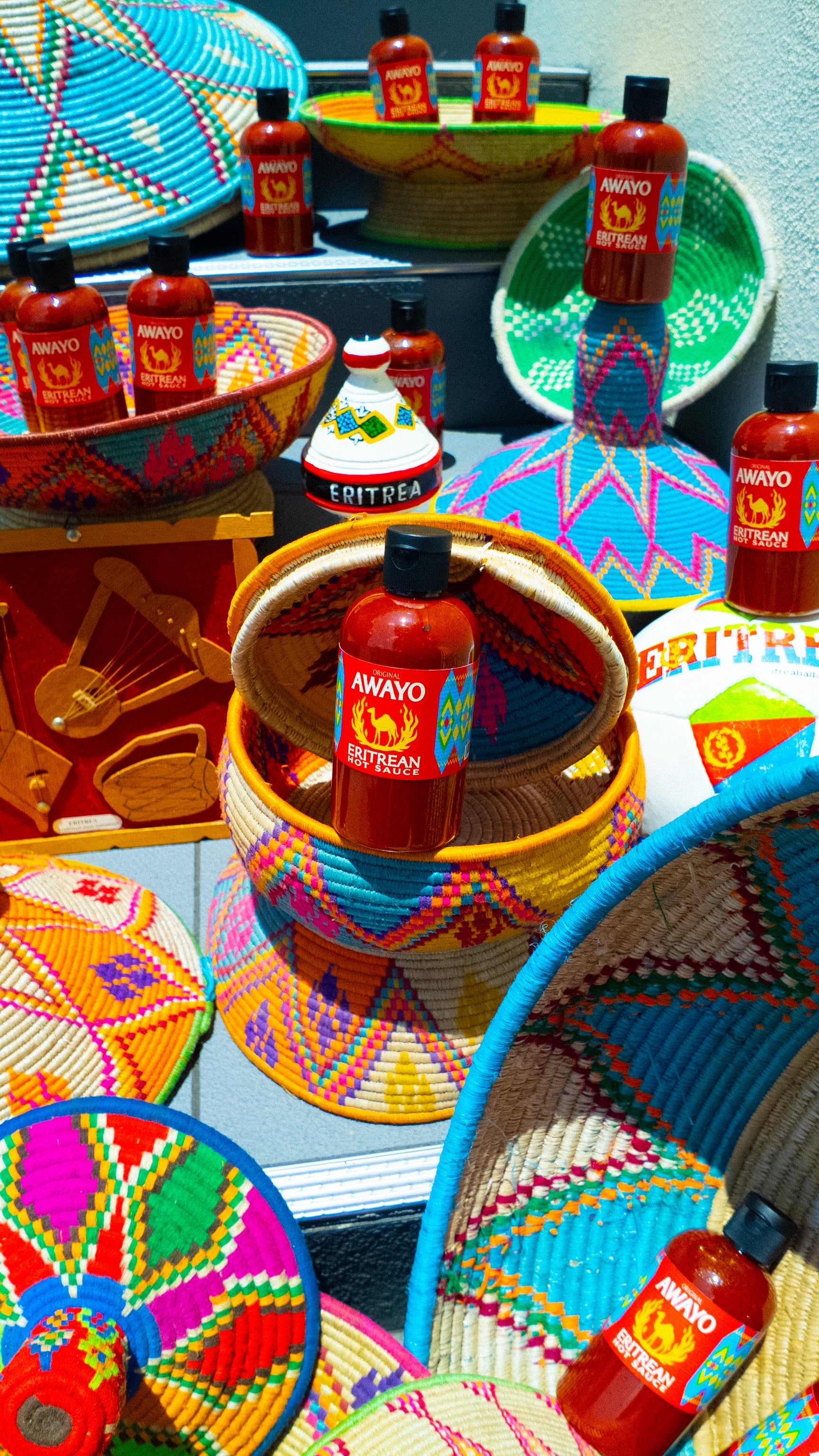 Awayo Eritrean Hot Sauce presented with East African baskets and art.